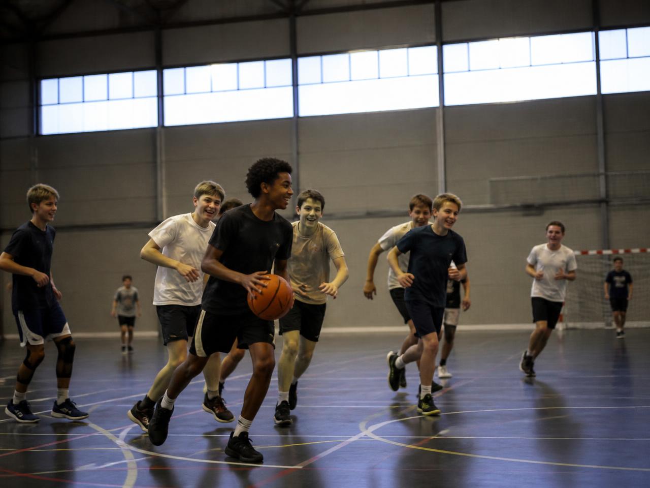 Young people playing indoor sport together in a sports hall